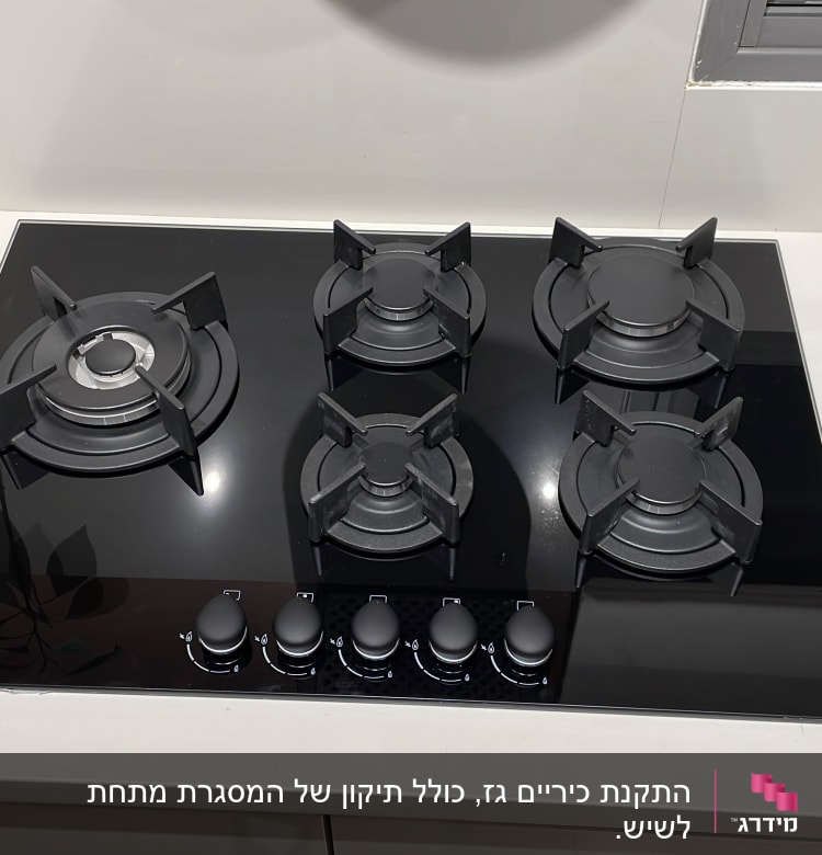 כיריים גז שחורות עם חמישה מבערים וכפתורי שליטה